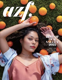 a woman laying on the ground with oranges on the cover of azf